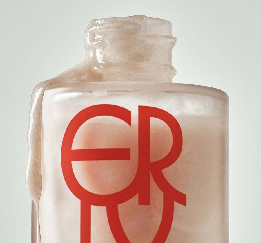 Serum bottle with a red logo on a light gray background