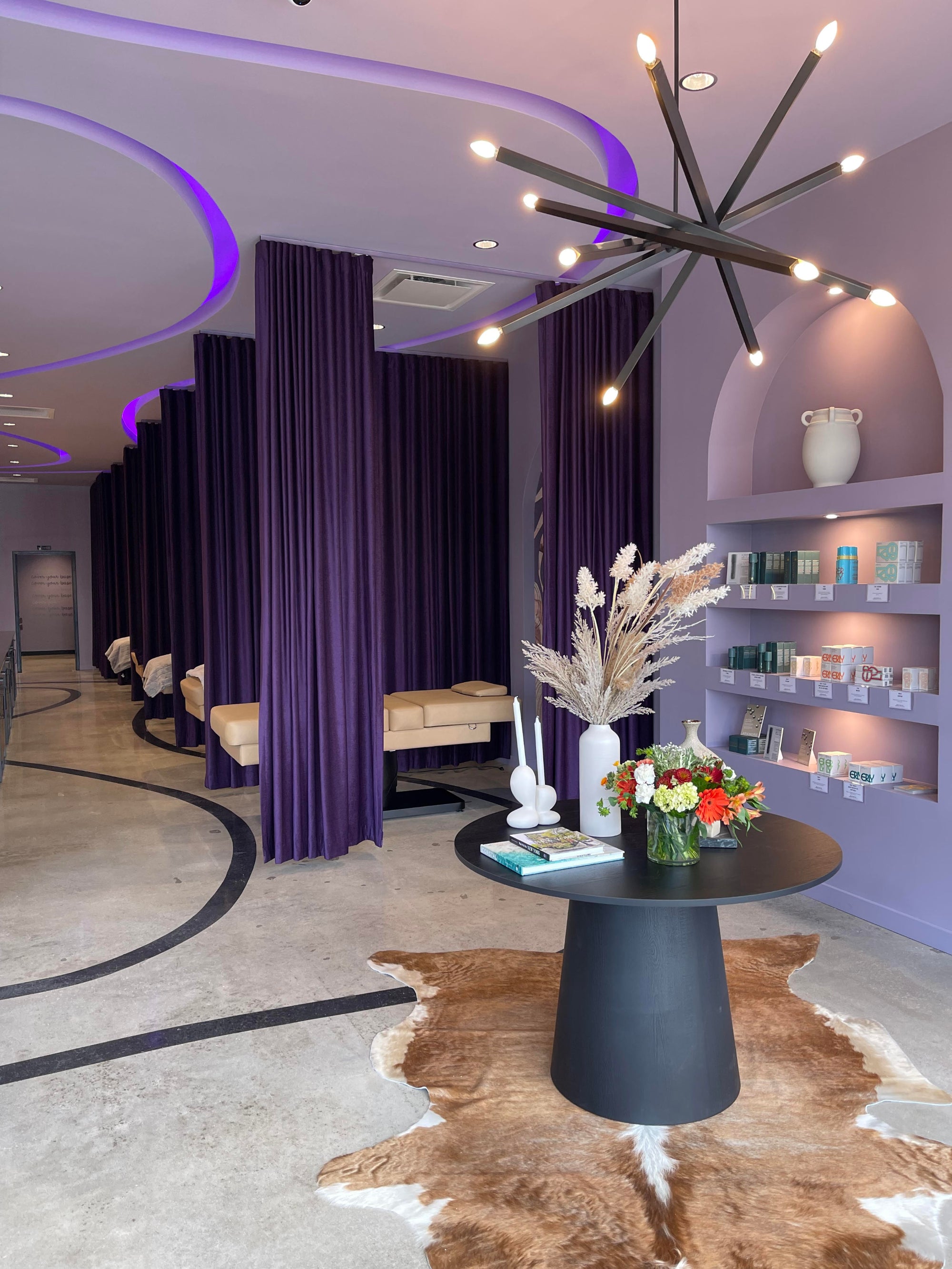 Modern interior design with purple curtains, a black table, and decorative elements.